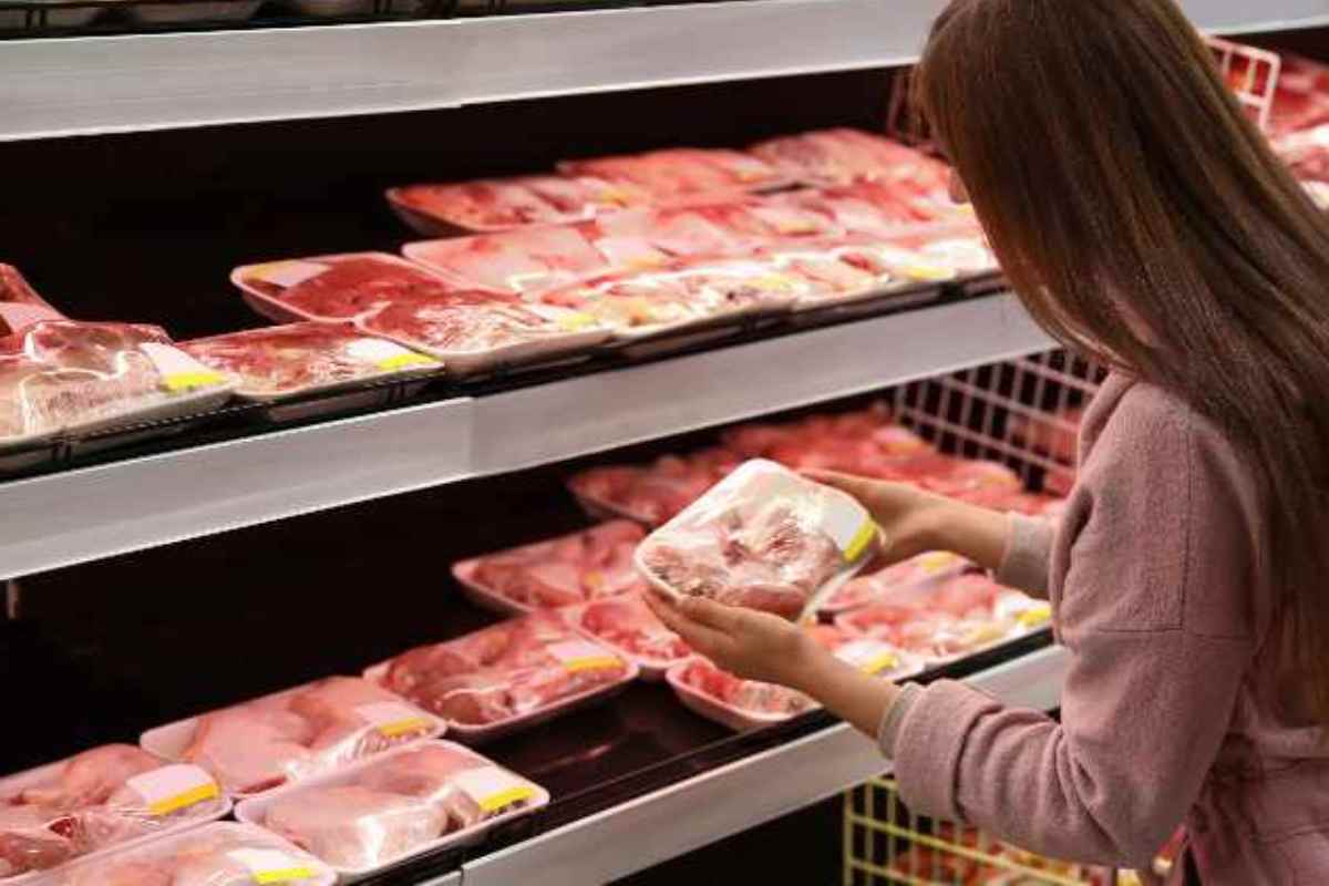 Donna sceglie pollo al supermercato